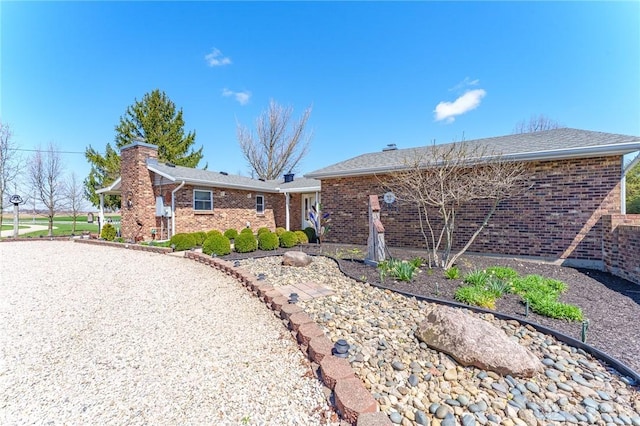 view of front of property featuring brick siding and a chimney