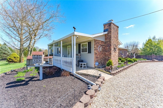 view of front of house with a chimney and covered porch