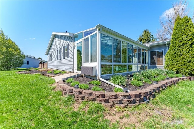 rear view of house with a sunroom and a lawn