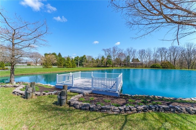 view of dock featuring a deck with water view and a lawn