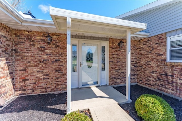 view of exterior entry featuring brick siding