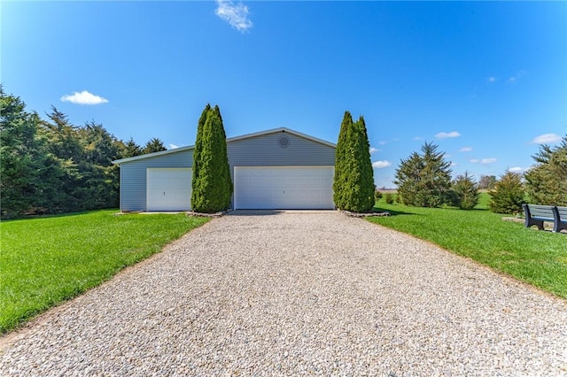 view of side of property with a yard, a garage, and an outbuilding