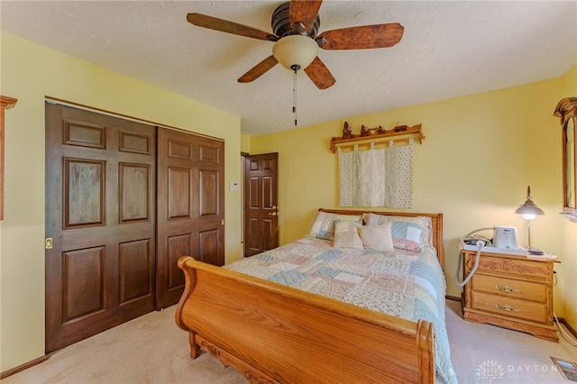 carpeted bedroom featuring a closet and ceiling fan