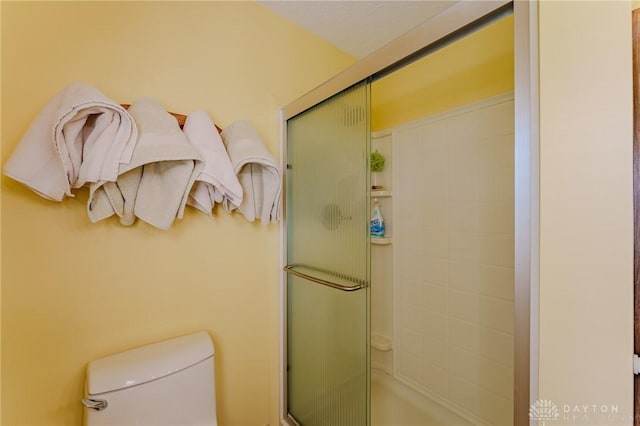 bathroom with toilet and a shower with shower door