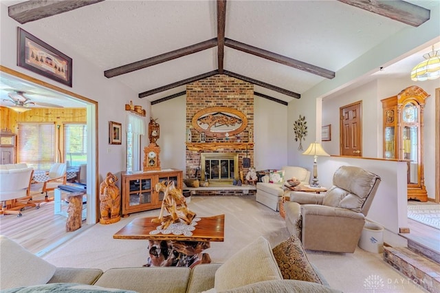 living room featuring a ceiling fan, carpet flooring, vaulted ceiling with beams, and a brick fireplace