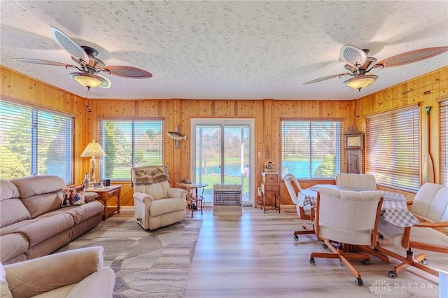 living room with a textured ceiling, ceiling fan, and plenty of natural light