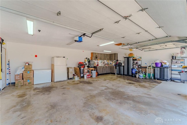 garage with freestanding refrigerator and a garage door opener