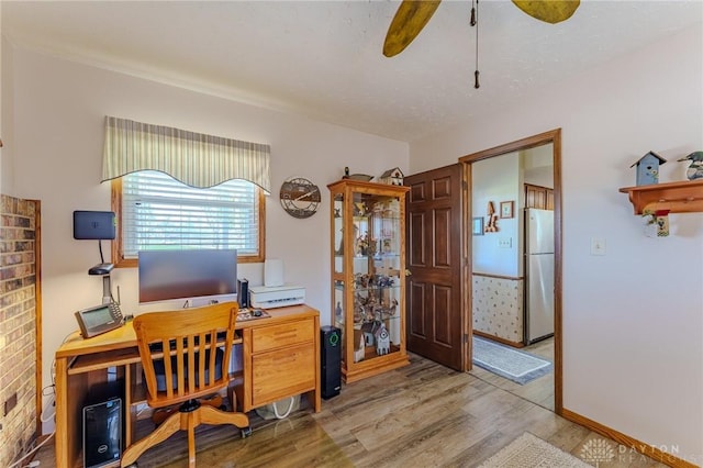 office space with light wood-style floors, baseboards, and a ceiling fan
