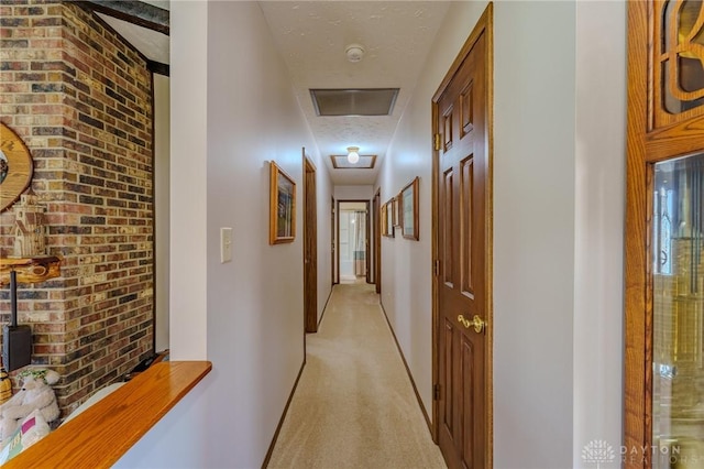 corridor with light carpet, brick wall, baseboards, and visible vents