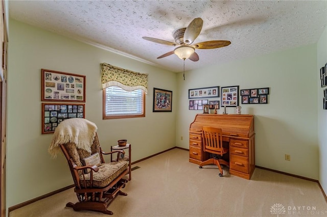 carpeted office space featuring ceiling fan, baseboards, and a textured ceiling