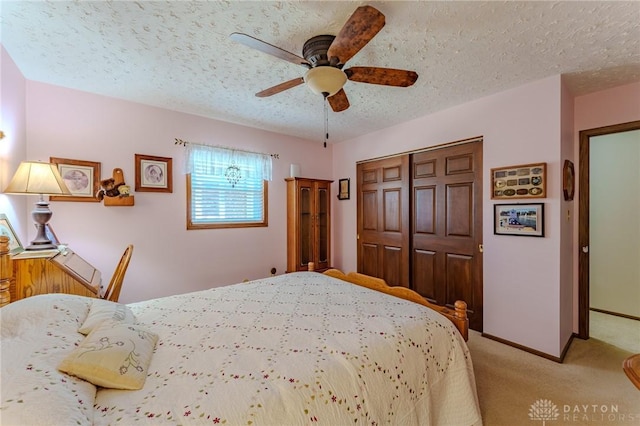 bedroom with ceiling fan, a textured ceiling, a closet, carpet floors, and baseboards