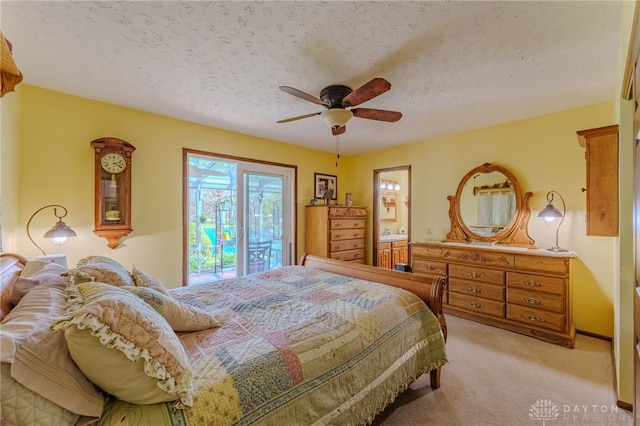 bedroom with a ceiling fan, a textured ceiling, ensuite bath, access to exterior, and light colored carpet