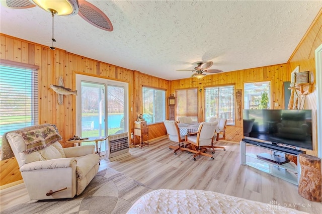 living area featuring ceiling fan, a wealth of natural light, and a textured ceiling
