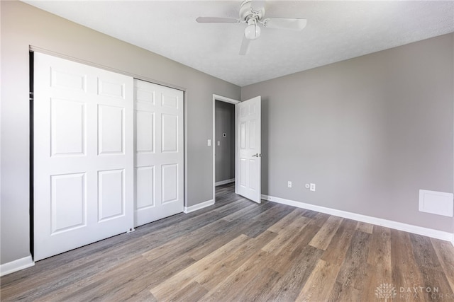1917 Beckert Dr, Piqua, OH 45356 - unfurnished bedroom with wood finished floors, baseboards, a closet, and a ceiling fan