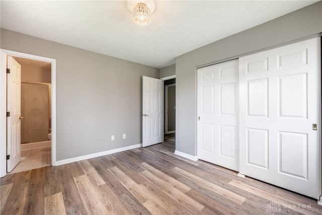 1917 Beckert Dr, Piqua, OH 45356 - unfurnished bedroom featuring light wood finished floors, baseboards, a closet, and connected bathroom