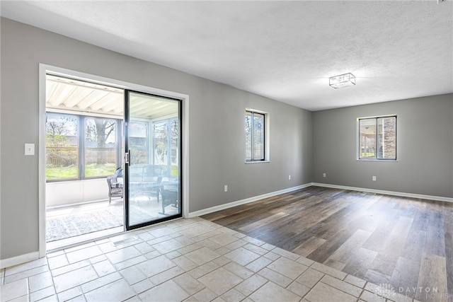 1917 Beckert Dr, Piqua, OH 45356 - unfurnished room featuring baseboards, wood finished floors, and a textured ceiling
