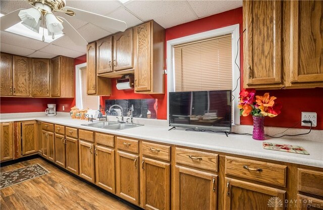 7045 US-40, New Carlisle, OH 45344 - kitchen featuring a paneled ceiling, a sink, wood finished floors, ceiling fan, and light countertops