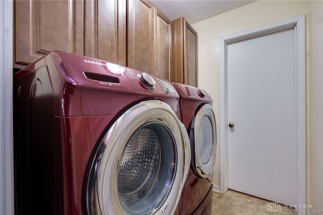 washroom featuring cabinet space and washer and clothes dryer