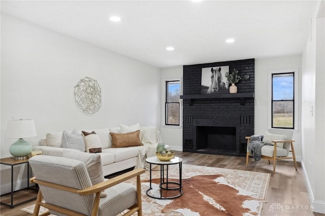 5850 Weidner Rd, Springboro, OH 45066 - living room with a brick fireplace, baseboards, wood finished floors, and a healthy amount of sunlight