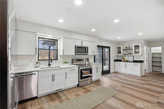 5850 Weidner Rd, Springboro, OH 45066 - kitchen featuring a sink, white cabinets, appliances with stainless steel finishes, and light wood-style floors