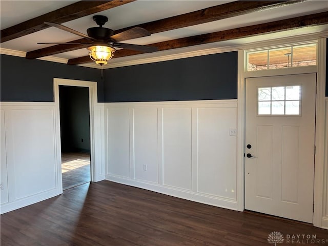 entryway featuring a decorative wall, dark wood-style flooring, a ceiling fan, beamed ceiling, and wainscoting
