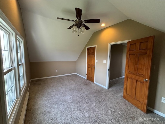 additional living space featuring a ceiling fan, vaulted ceiling, carpet flooring, a baseboard radiator, and baseboards