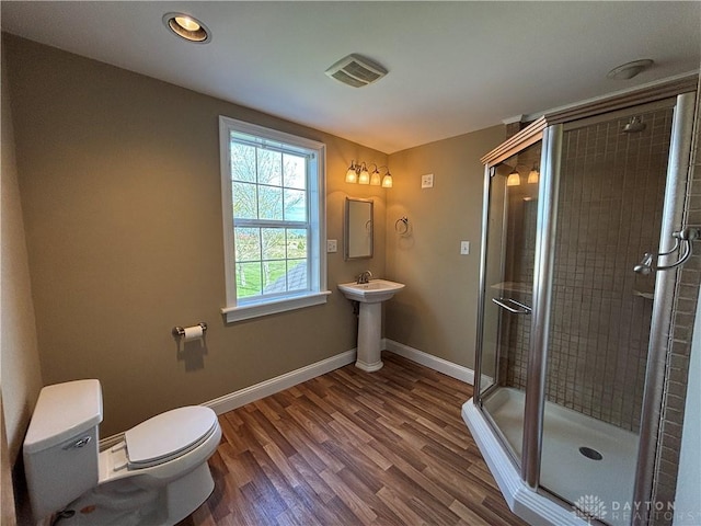 full bathroom with baseboards, toilet, a shower stall, visible vents, and wood finished floors