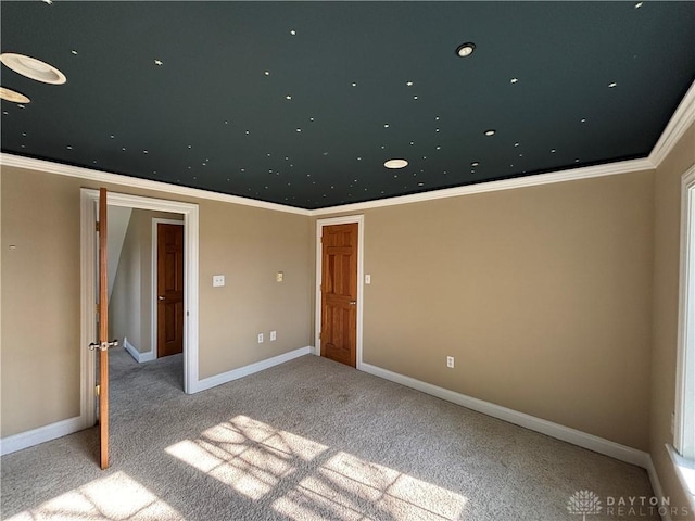 carpeted spare room featuring ornamental molding and baseboards