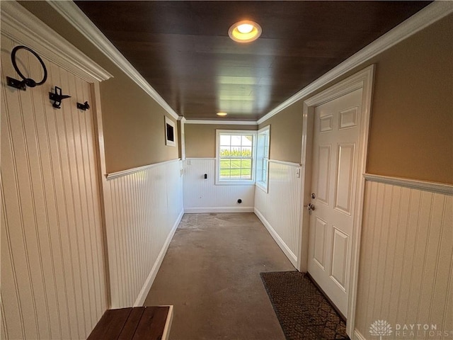 corridor with ornamental molding, a wainscoted wall, and visible vents