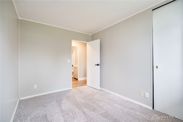 unfurnished room with crown molding, baseboards, and light carpet