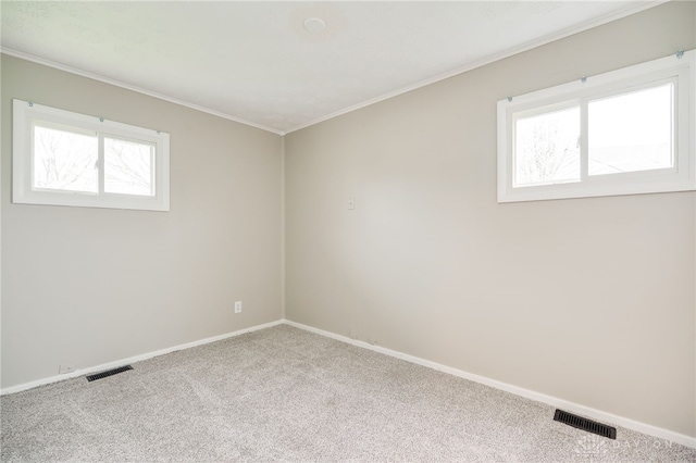 carpeted empty room with visible vents, baseboards, and ornamental molding