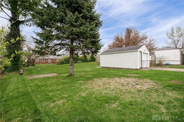 view of yard with an outdoor structure, a garage, and fence