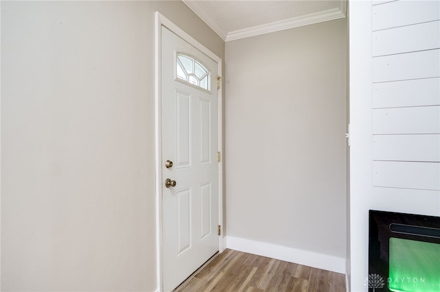 doorway featuring light wood-style flooring, baseboards, and ornamental molding