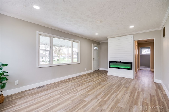 unfurnished living room with a textured ceiling, visible vents, recessed lighting, a large fireplace, and ornamental molding