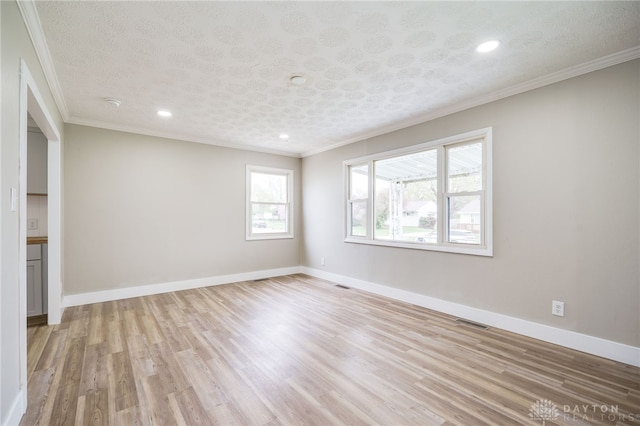 spare room with light wood-type flooring and crown molding