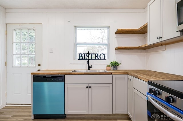 kitchen featuring open shelves, stainless steel appliances, butcher block countertops, and a sink