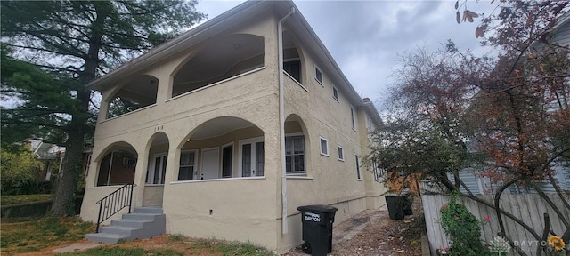view of front of house featuring stucco siding and a balcony