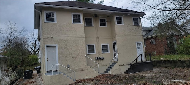 rear view of property with entry steps and stucco siding