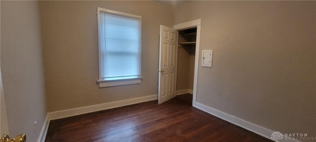 unfurnished bedroom featuring baseboards and dark wood finished floors