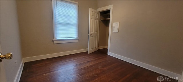 unfurnished bedroom featuring baseboards and dark wood finished floors