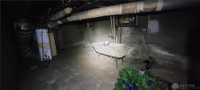 unfinished below grade area featuring water heater and a sink