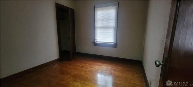 empty room with wood finished floors and baseboards