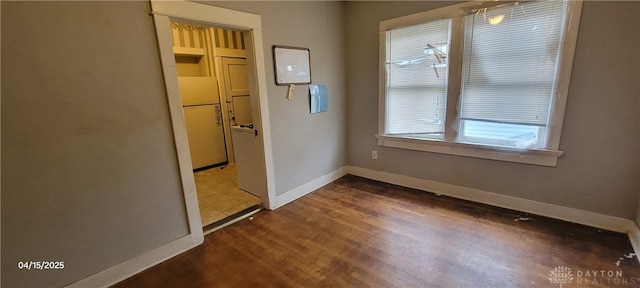 unfurnished room featuring baseboards and wood finished floors