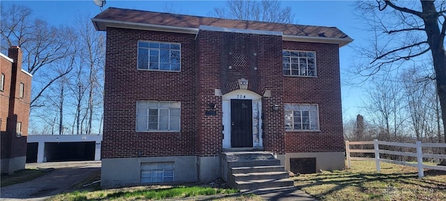 view of front of house with fence, entry steps, and brick siding