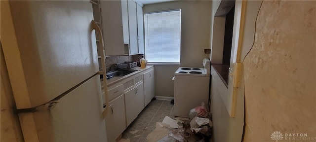kitchen with white cabinetry, white appliances, baseboards, and a sink