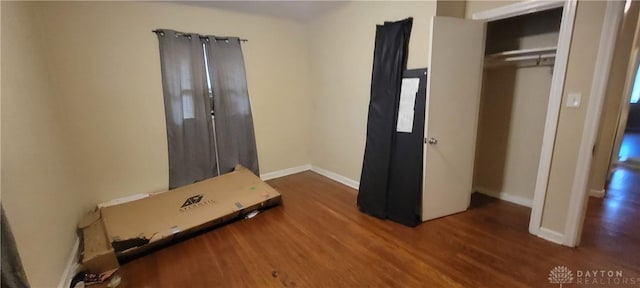 bedroom featuring baseboards and wood finished floors