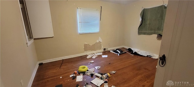 spare room featuring baseboards, visible vents, and wood finished floors