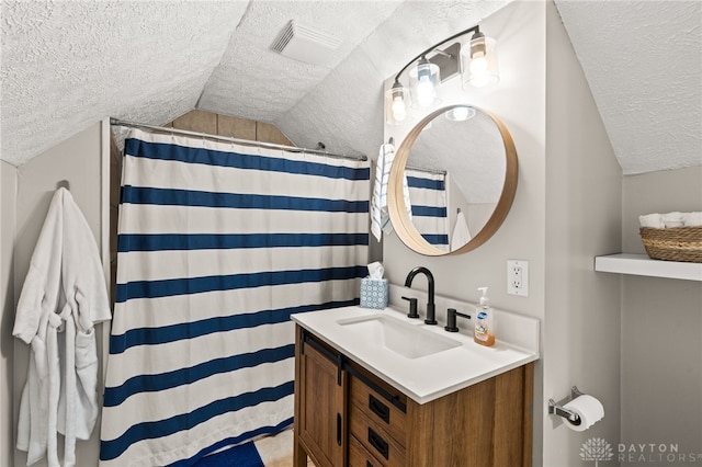 full bath with visible vents, a shower with curtain, a textured ceiling, vanity, and vaulted ceiling