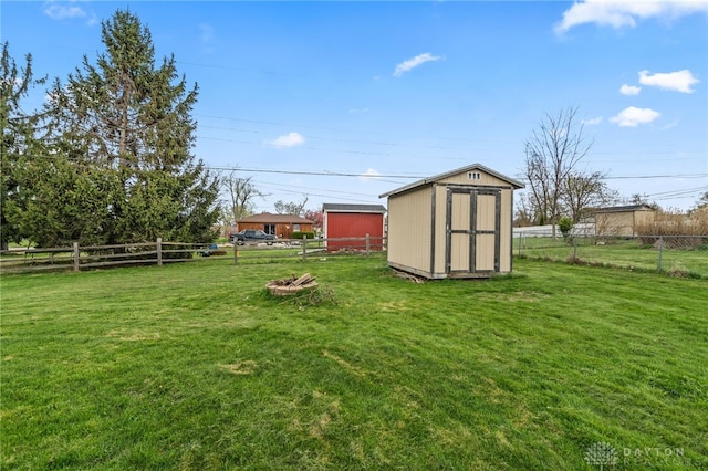 view of yard featuring a shed, a fenced backyard, and an outdoor structure