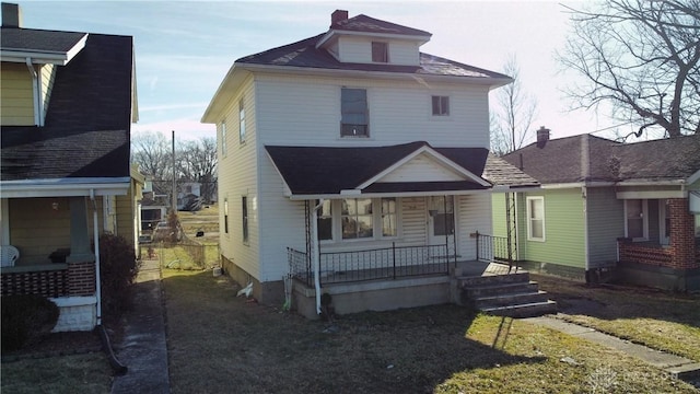 traditional style home featuring a porch and a front yard